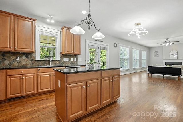 5807 Mctaggart Ln, Charlotte, NC 28269 - kitchen with dark wood finished floors, a kitchen island, backsplash, ceiling fan, and open floor plan