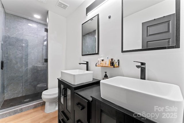 5501 Joyce Dr, Charlotte, NC 28215 - full bathroom with toilet, wood finished floors, a stall shower, vanity, and recessed lighting