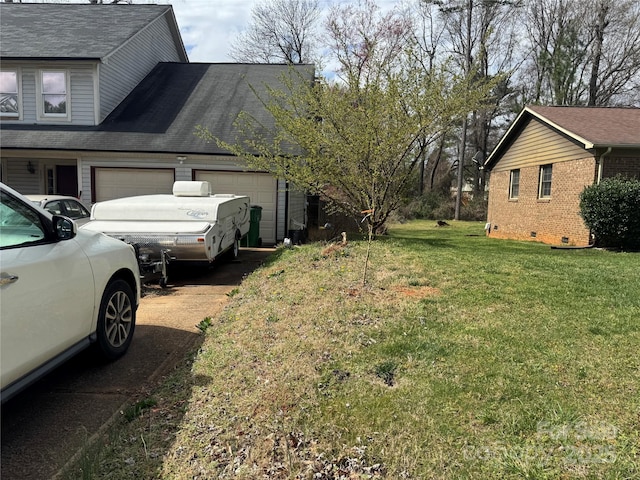 view of home's exterior featuring an attached garage, a lawn, driveway, and a shingled roof
