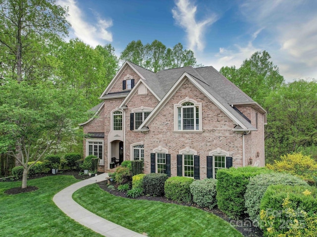 view of front of home featuring brick siding and a front yard