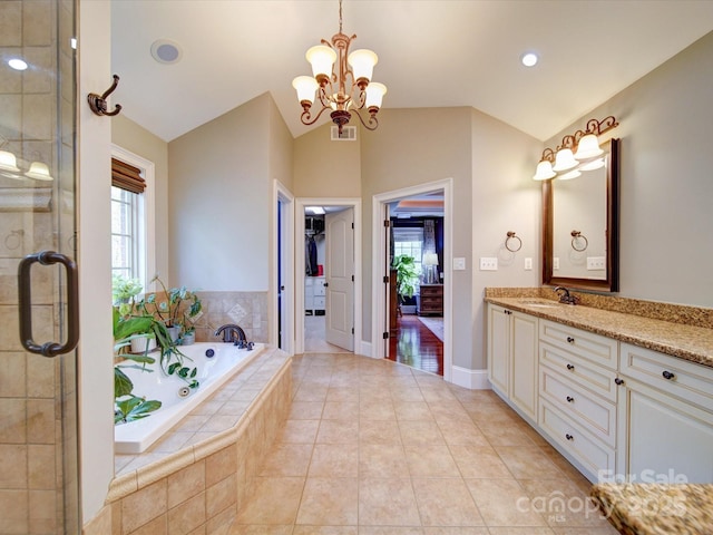 bathroom featuring visible vents, a garden tub, vanity, an inviting chandelier, and vaulted ceiling