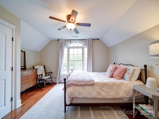 bedroom with a ceiling fan, visible vents, wood finished floors, and lofted ceiling