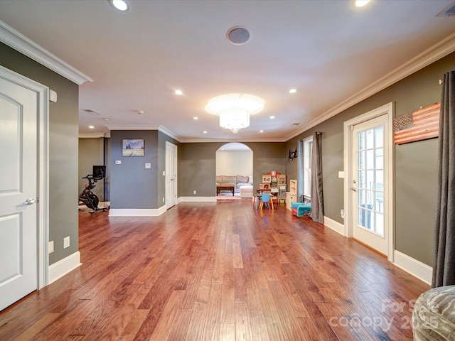 recreation room featuring crown molding, arched walkways, wood finished floors, and recessed lighting