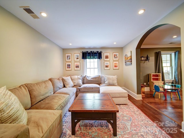 living area with arched walkways, recessed lighting, baseboards, wood finished floors, and visible vents