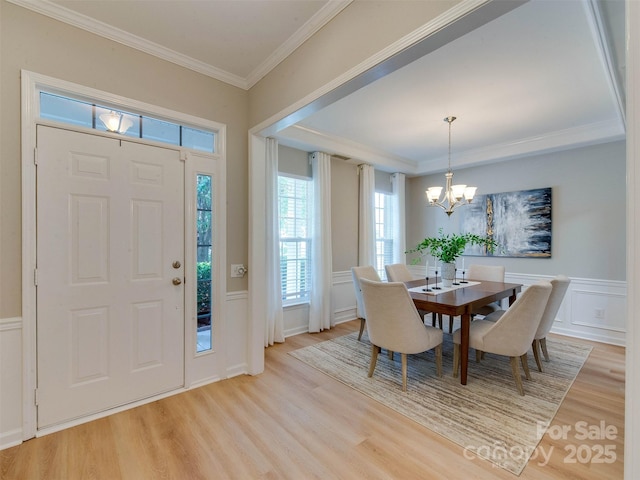 9607 Kestral Ridge Dr, Charlotte, NC 28269 - foyer with light wood-style floors, a decorative wall, a chandelier, crown molding, and plenty of natural light