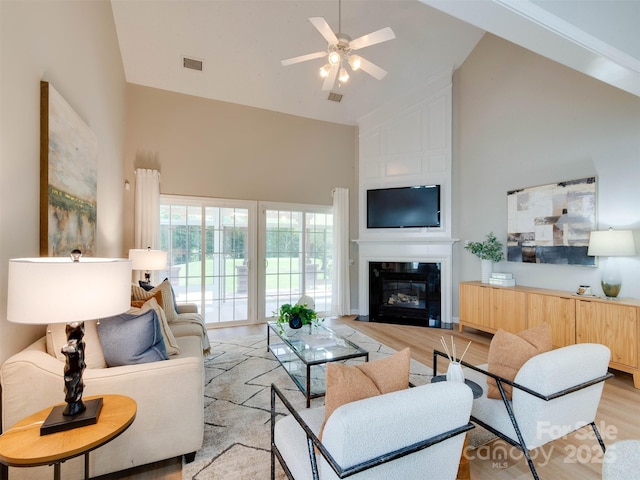 9607 Kestral Ridge Dr, Charlotte, NC 28269 - living room with high vaulted ceiling, light wood-style floors, a ceiling fan, and a fireplace
