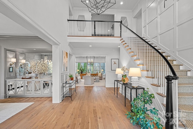 19117 Davidson Concord Rd, Davidson, NC 28036 - entrance foyer with a chandelier, a decorative wall, stairway, wood-type flooring, and a high ceiling