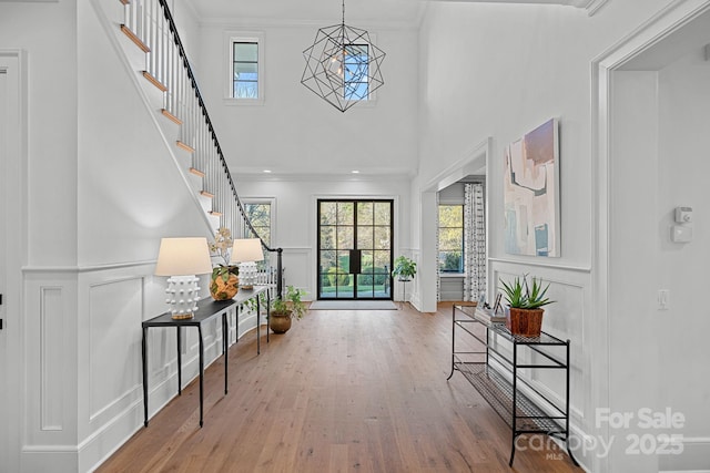 19117 Davidson Concord Rd, Davidson, NC 28036 - foyer featuring a decorative wall, a towering ceiling, healthy amount of natural light, wood finished floors, and ornamental molding