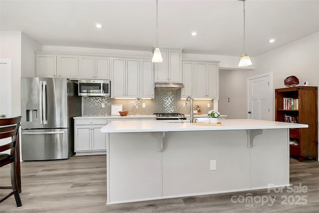 1032 Barnette Farm Ln, Monroe, NC 28110 - kitchen with stainless steel appliances, light countertops, light wood-style floors, decorative backsplash, and recessed lighting