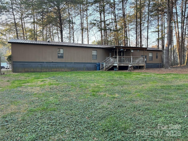 rear view of property featuring a lawn and a wooden deck