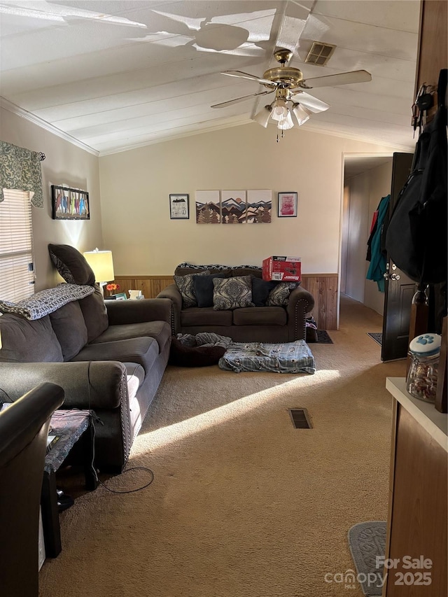 living room with carpet flooring, wood walls, visible vents, lofted ceiling, and wainscoting