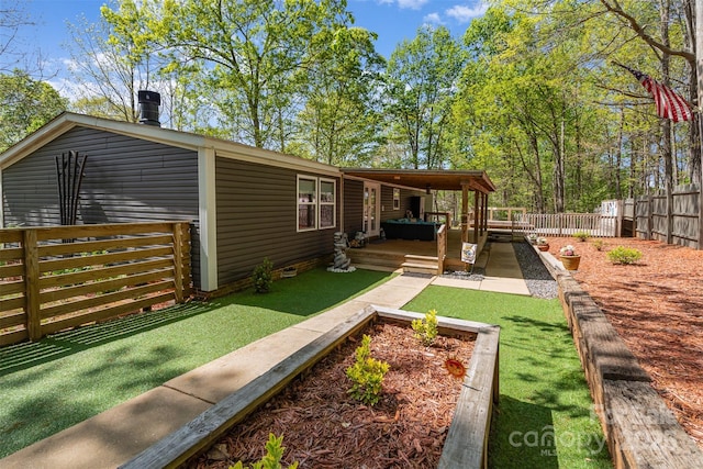 back of property with a fenced backyard, a deck, and a lawn