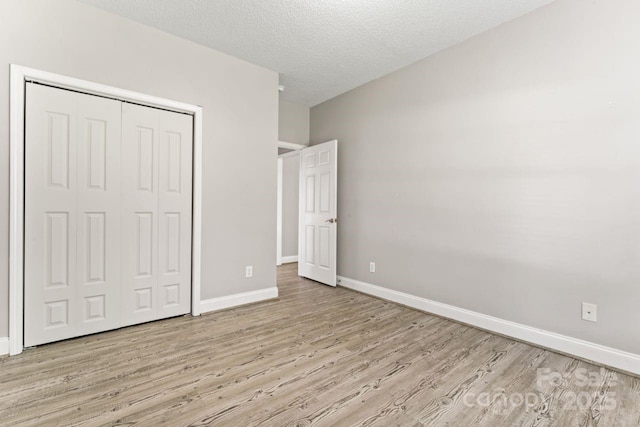 145 Mcbride Dr, Rockwell, NC 28138 - unfurnished bedroom featuring wood finished floors, baseboards, a closet, and a textured ceiling