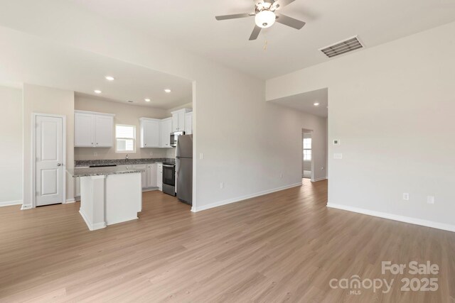 kitchen with visible vents, a ceiling fan, open floor plan, stainless steel appliances, and light wood finished floors