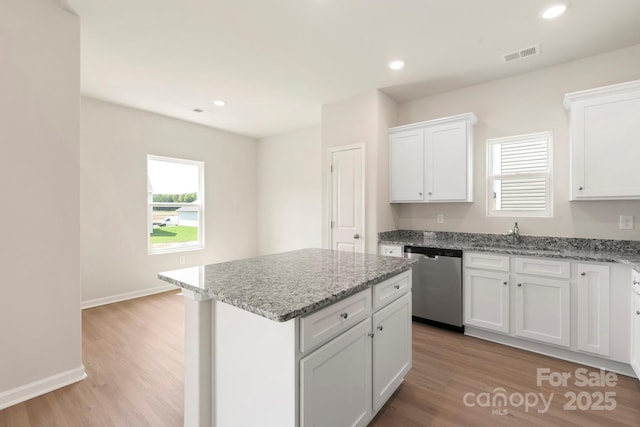 kitchen featuring visible vents, plenty of natural light, dishwasher, and a sink