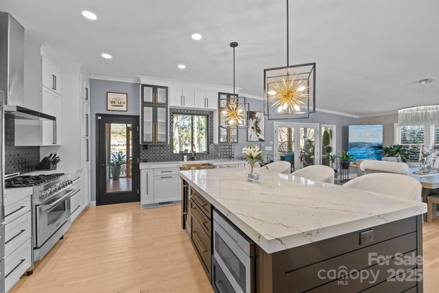 15921 Cramur Dr, Huntersville, NC 28078 - kitchen with a notable chandelier, crown molding, white cabinetry, appliances with stainless steel finishes, and a center island