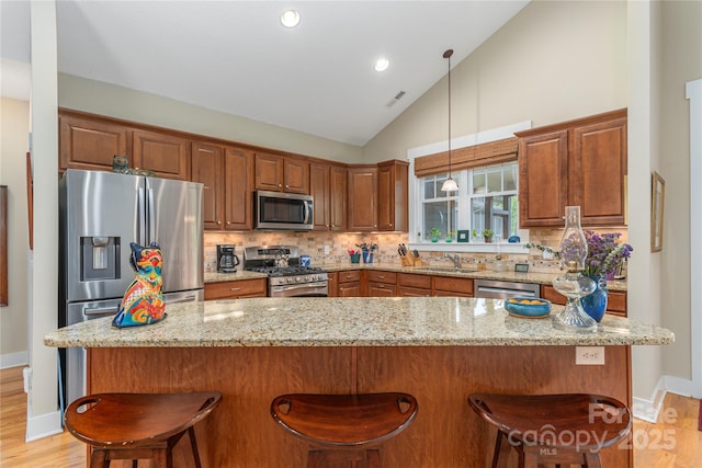 4 Silo View Ct, Asheville, NC 28804 - kitchen with stainless steel appliances, backsplash, a sink, a breakfast bar area, and high vaulted ceiling