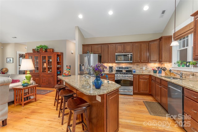 4 Silo View Ct, Asheville, NC 28804 - kitchen featuring appliances with stainless steel finishes, a sink, light wood-style floors, decorative backsplash, and vaulted ceiling
