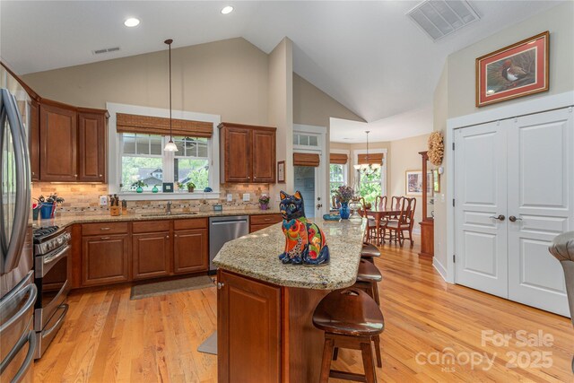 4 Silo View Ct, Asheville, NC 28804 - kitchen featuring a sink, stainless steel appliances, a kitchen breakfast bar, brown cabinets, and light wood-style flooring