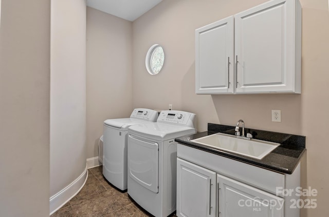 laundry room with washing machine and clothes dryer, cabinet space, a sink, and baseboards
