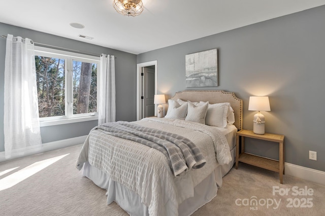 carpeted bedroom featuring baseboards and visible vents