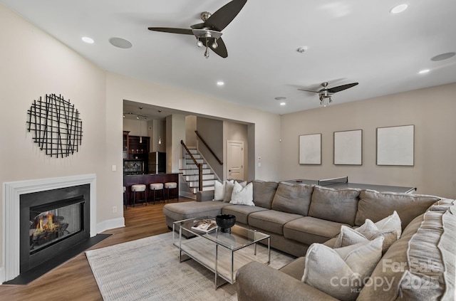living area with wood finished floors, recessed lighting, stairs, and ceiling fan