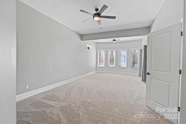 carpeted spare room with baseboards and a ceiling fan