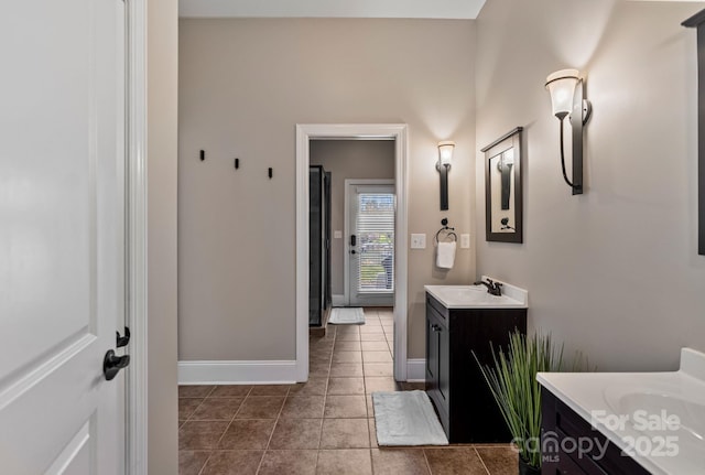 full bathroom with tile patterned floors, a sink, two vanities, and baseboards