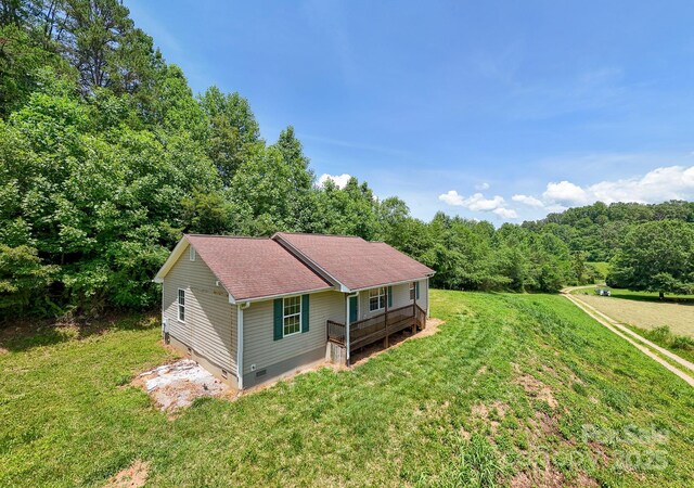 42 Leonard Davis Rd, Robbinsville, NC 28771 - view of front of house with crawl space, a front lawn, a shingled roof, a wooded view, and a wooden deck