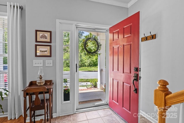 foyer featuring light tile patterned floors and ornamental molding