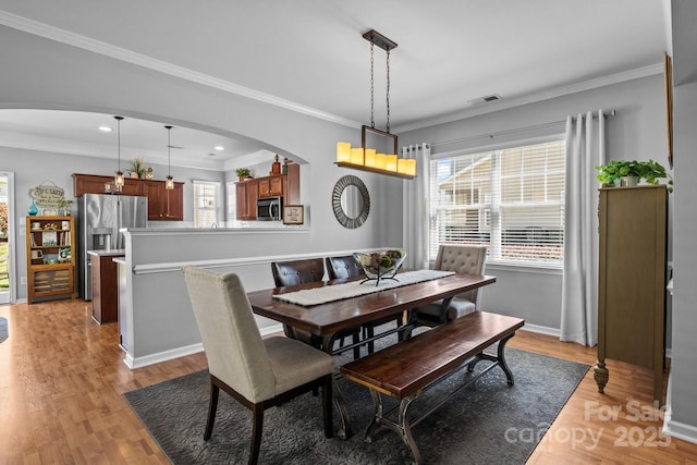 dining space with arched walkways, visible vents, and a wealth of natural light