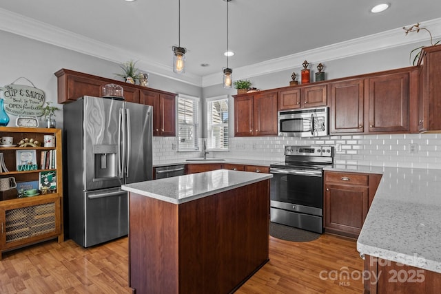 kitchen featuring a sink, stainless steel appliances, light wood-style flooring, backsplash, and light stone countertops