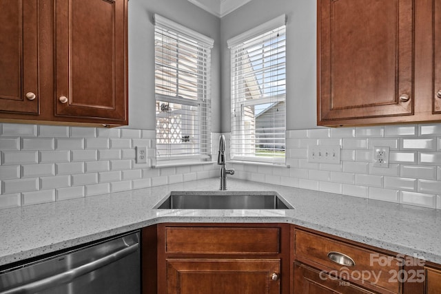 kitchen with decorative backsplash, stainless steel dishwasher, a sink, and plenty of natural light