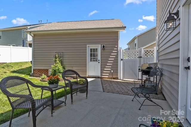 view of patio with fence, a gate, and area for grilling