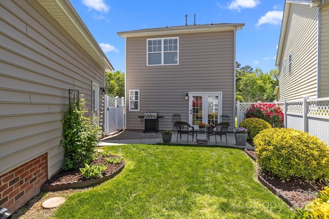 rear view of property featuring a lawn, a patio, and fence private yard