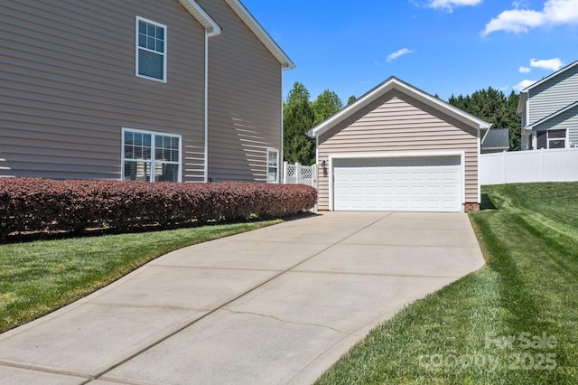 view of property exterior with fence, a yard, and a detached garage