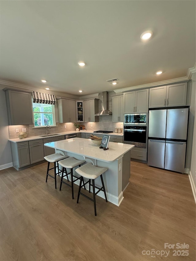 317 Maidstone Dr Unit 57, Monroe, NC 28110 - kitchen featuring appliances with stainless steel finishes, wall chimney range hood, gray cabinets, a center island, and recessed lighting