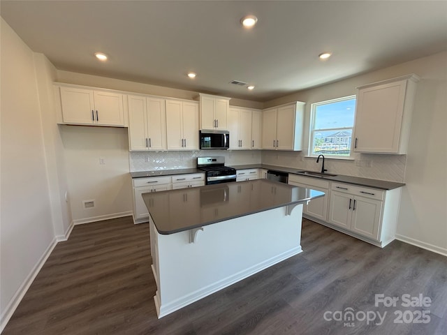 317 Maidstone Dr Unit 57, Monroe, NC 28110 - kitchen featuring appliances with stainless steel finishes, dark countertops, white cabinets, a center island, and recessed lighting