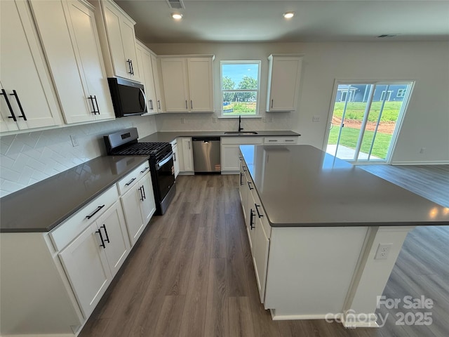 317 Maidstone Dr Unit 57, Monroe, NC 28110 - kitchen featuring stainless steel appliances, dark countertops, a kitchen island, dark wood-style flooring, and white cabinetry