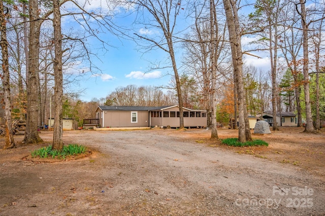view of front facade with driveway, a sunroom, and an outdoor structure