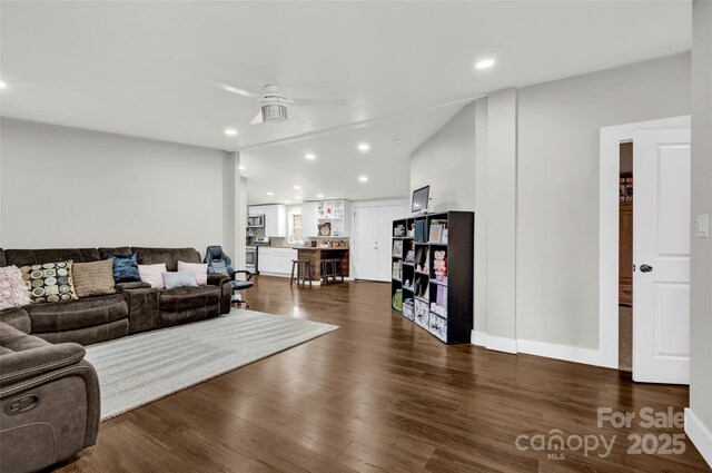 living room with baseboards, ceiling fan, recessed lighting, and dark wood-style flooring