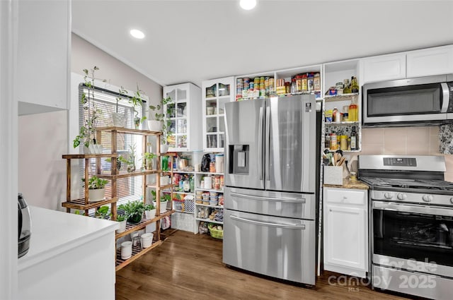 kitchen with recessed lighting, appliances with stainless steel finishes, dark wood-type flooring, white cabinetry, and backsplash