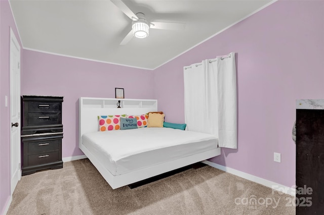 carpeted bedroom with baseboards, vaulted ceiling, ornamental molding, and a ceiling fan