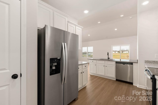 3327 Burberry Dr, Gastonia, NC 28052 - kitchen with a sink, stainless steel appliances, light wood-style flooring, and white cabinetry