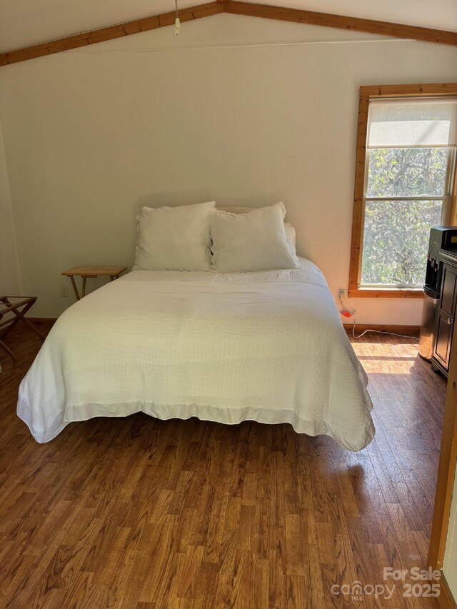 bedroom with dark wood-style flooring and vaulted ceiling