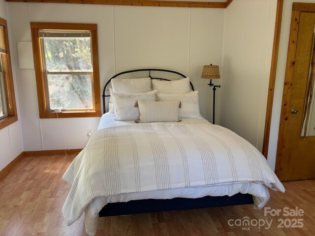 bedroom with wood finished floors and baseboards