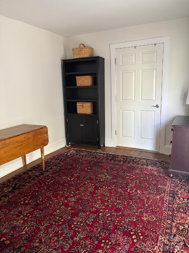 interior space featuring dark wood-type flooring and baseboards