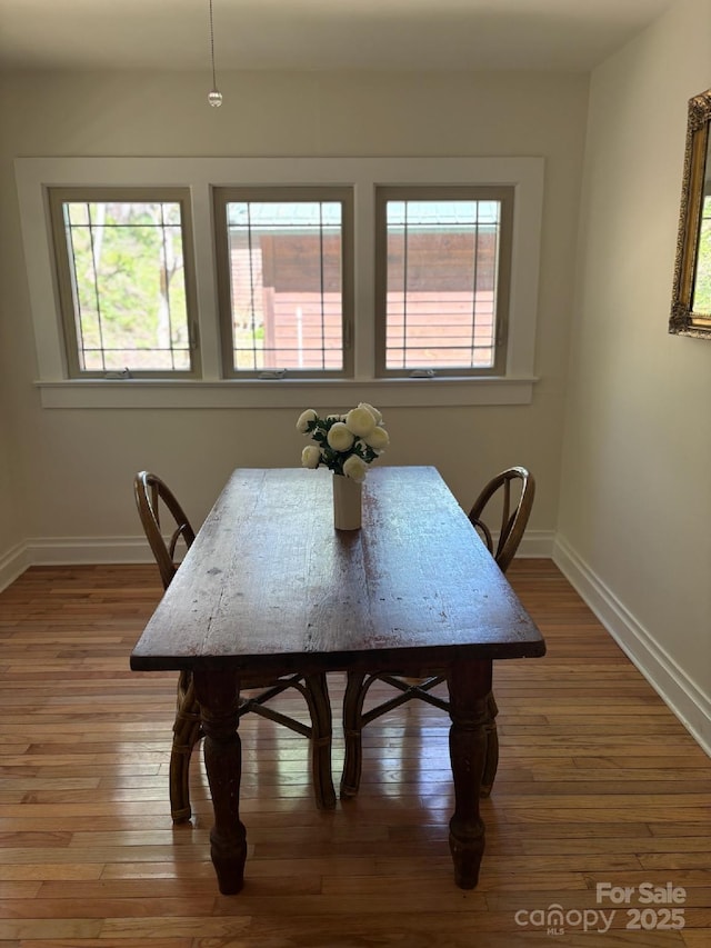 dining room featuring wood-type flooring and baseboards