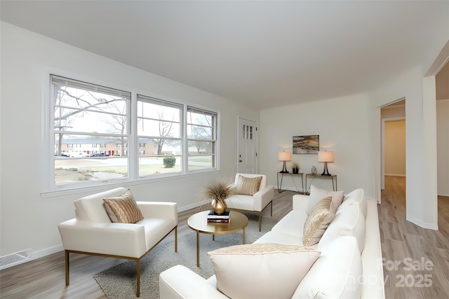 living area with visible vents, baseboards, and light wood finished floors