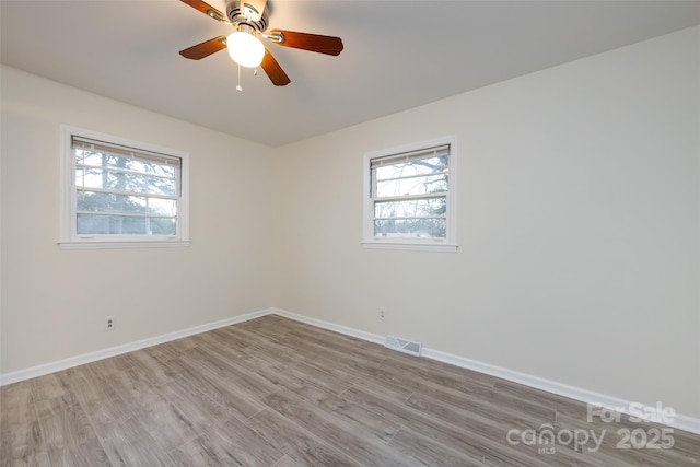 spare room featuring visible vents, wood finished floors, and baseboards